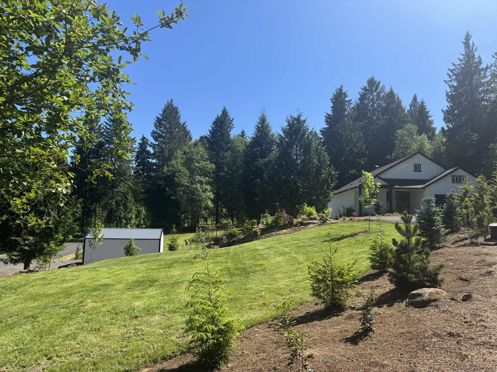 Sloped lawn with newly mulched planting beds and young trees